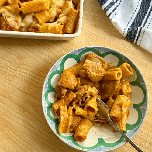 Butter chicken pasta served in a bowl with creamy tomato butter sauce and herbs