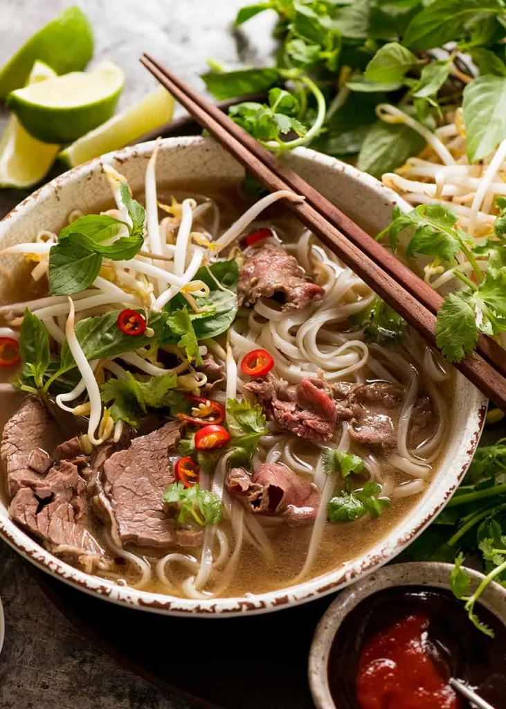 Vietnamese pho with rice noodles, herbs, and aromatic broth