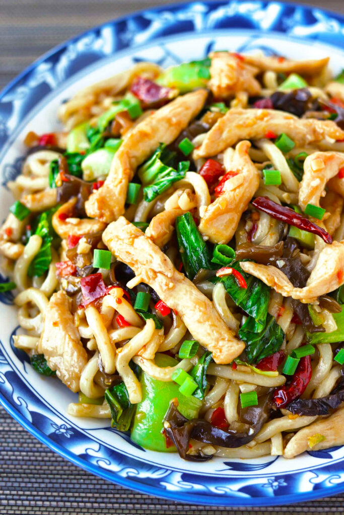 Close-up of sticky garlic chicken noodles with saucy noodles and chicken