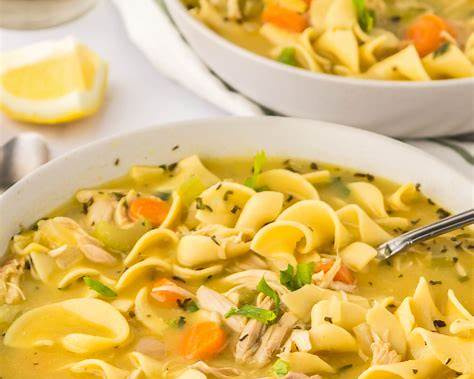 Chicken noodle soup garnished with fresh herbs